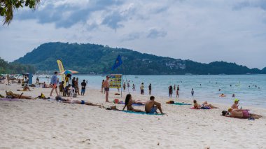 Patong plajı Phuket Tayland Kasım 2022, Tayland 'da yüksek mevsimde plaj sandalyeleri ve palmiye ağaçları olan tropik plaj manzarası