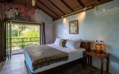 Koh Kood Tayland Ekim 2022, Lüks Asyalı yatak odası Tayland 'da bir tropikal bahçede tatil bungalovunda.