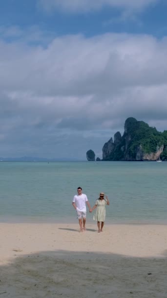 남자와 여자가 햇살을 받으며 해변을 — 비디오