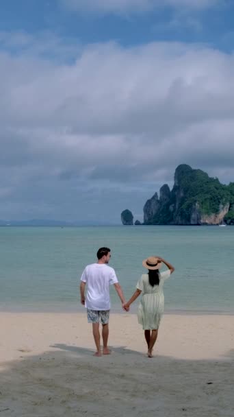 남자와 여자가 햇살을 받으며 해변을 — 비디오
