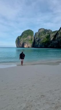 Koh Phi Phi Tayland sahilinde yürüyen şapkalı adamlar. Maya Körfezi 'ndeki Tayland' ın ünlü plajı.
