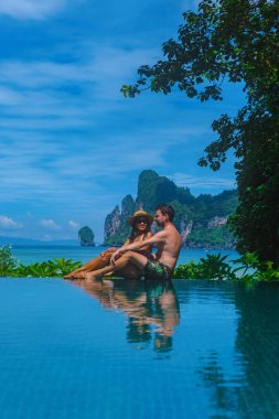 Sonsuzluk havuzunda Koh Phi Tayland sahiline bakan bir çift erkek ve kadın.
