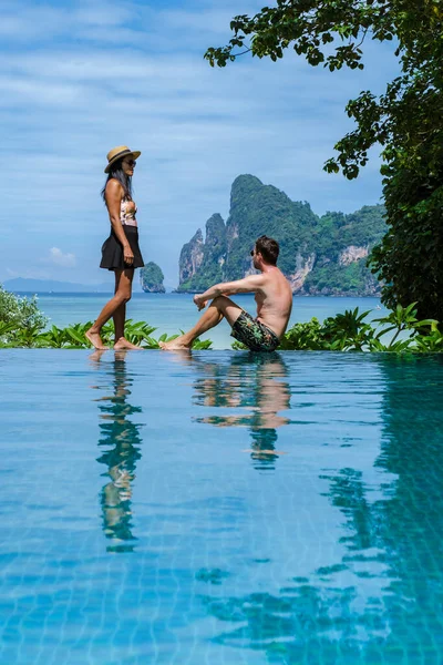 Stock image couple of caucasian men and Thai women at the infinity pool looking out over the beach of Koh Phi Phi Thailand