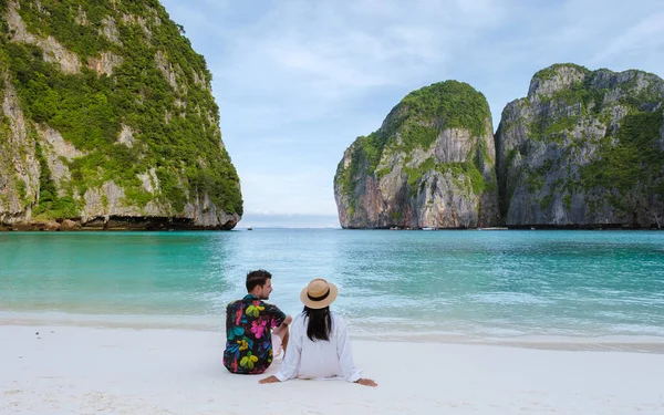 一对夫妇坐在海滩上凝视着大海 泰国妇女和高加索男子带着草皮色的大海在玛雅湾海滩上散步 — 图库照片
