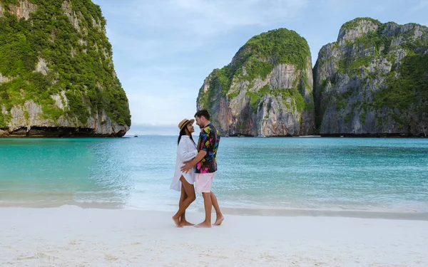 ビーチで抱き合っているカップル タイ人女性と白人男性は タークース色の海と朝のマヤ湾ビーチコピピタイのビーチを歩く — ストック写真