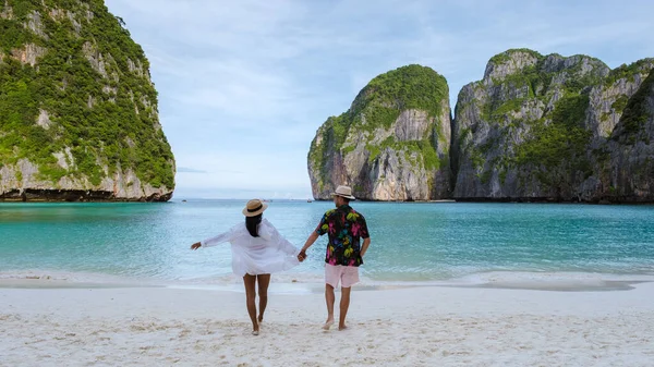 熱帯のビーチを歩く新婚旅行の男性と女性のカップル — ストック写真