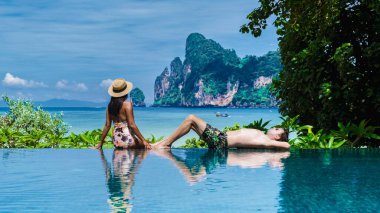 Sonsuzluk havuzunda Koh Phi Tayland sahiline bakan bir çift erkek ve kadın.