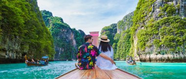 Taylandlı kadınlar ve Kafkasyalı erkekler Koh Phi Tayland gölünde uzun kuyruklu bir teknenin önünde. Pileh Gölü Tayland Koh Phi Phi