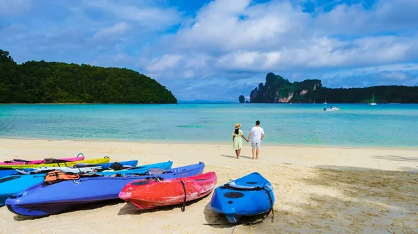 stock image Koh Ph Phi Thailand, a couple of men, and women walking on the beach in the morning sun with turquoise colored ocean