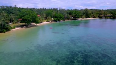 Erkekler ve kadınlar, Tayland 'da Koh Mak Adası' nda tropik bir plajda kanoda.. 