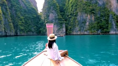 Koh Phi Phi Tayland 'da yeşil zümrüt okyanuslu Pileh Lagoon, Taylandlı kadınlar uzun kuyruklu teknenin önünde.