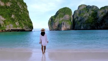Koh Phi Phi Tayland sahilinde yürüyen şapkalı kadınlar. Maya Körfezi 'ndeki Tayland' ın ünlü plajı.