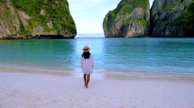 Koh Phi Phi Tayland sahilinde yürüyen şapkalı kadınlar. Maya Körfezi 'ndeki Tayland' ın ünlü plajı.