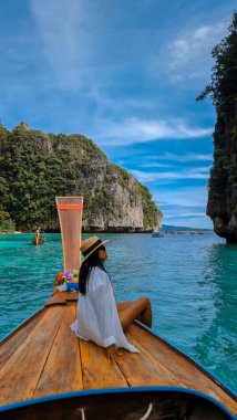 Pileh Lagoon Koh Phi Tayland 'da uzun kuyruklu bir teknenin önünde Asyalı Taylandlı kadınlar.