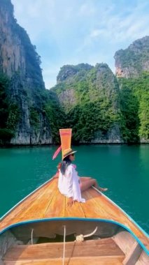 Taylandlı kadınlar Pileh Lagoon Koh Phi Tayland 'da uzun kuyruklu bir teknenin önünde,
