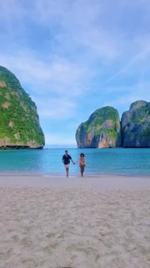 Sabahleyin May Bay Koh Phi Phi Tayland sahilinde yürüyen bir çift kadın ve erkek.