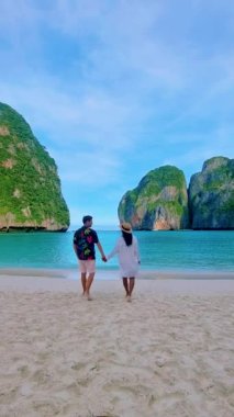 Sabahleyin May Bay Koh Phi Phi Tayland sahilinde yürüyen bir çift kadın ve erkek.