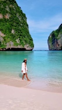 Taylandlı kadınlar Maya Körfezi Koh Phi Tayland 'da bir şapkayla sahilde yürüyorlar..