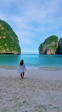 Taylandlı kadınlar Maya Körfezi Koh Phi Tayland 'da bir şapkayla sahilde yürüyorlar..