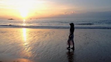 Taylandlı kadınlar Khao Lak Tayland 'da gün batımında sahilde yürürler.. 