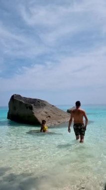 Beyaz plajda beyaz erkek ve Taylandlı kadın ve turkuvaz renkli okyanus ve Similan Adaları Tayland 'da denizde dev kayalar.. 