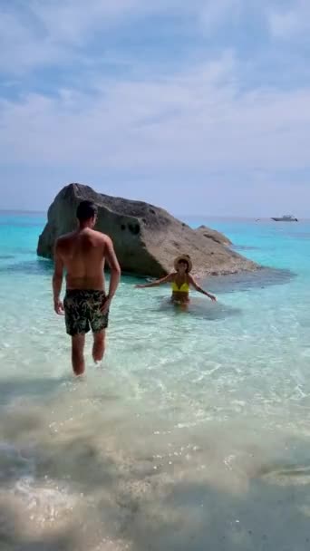シミラン諸島の海に巨大な岩があるカップルの男性と女性とターコイズ色の海タイ — ストック動画