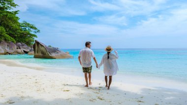 Similan Adaları Tayland 'ın turkuvaz renkli okyanusu olan tropikal beyaz plajda bir çift kadın ve erkek.. 