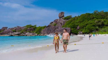 Similan Adaları 'ndaki tropikal beyaz plajda yaşayan erkek ve kadınlar Tayland. 
