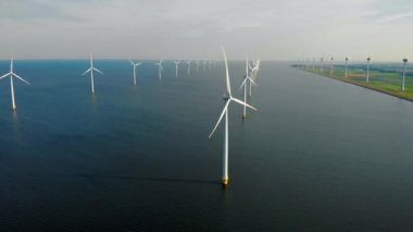 Denizdeki yel değirmeni türbinleri Hollanda 'da yeşil enerji üreten büyük bir yel değirmeni parkında yukarıdan insansız hava aracı görüntüsünden görülüyor.
