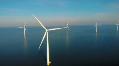 Denizdeki yel değirmeni türbinleri Hollanda 'da yeşil enerji üreten büyük bir yel değirmeni parkında yukarıdan insansız hava aracı görüntüsünden görülüyor.