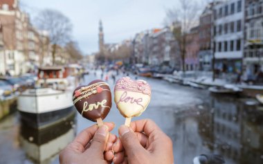 Sevgililer Günü 'nde Amsterdam şehir gezisinde romantik dondurmalar ve arka planda insanlar Amsterdam' ın donmuş kanallarında buz pateni yapıyorlar. Sevgililer Günü Romantik Konsepti.. 