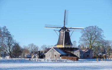 Hollanda 'da kış boyunca kardaki ahşap yel değirmeni. Hollanda 'da kar ve yel değirmeniyle soğuk hava