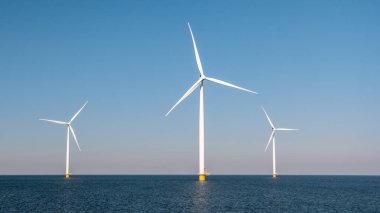 Hollanda 'da yel değirmeni türbinleri mavi gökyüzü ile denizde
