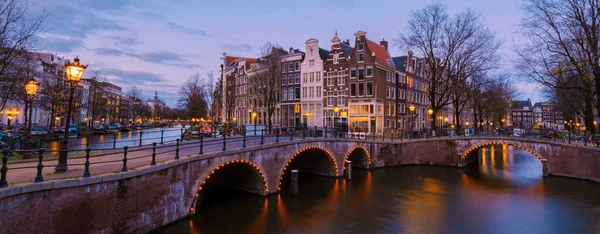 stock image Amsterdam Netherlands canals during sunset with lights in the evening in December during wintertime in the Netherlands Amsterdam city. Europe.