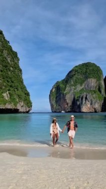 Maya Körfezi 'ndeki Koh Phi Phi Thailand plajında yürüyen bir çift, Asyalı kadınlar ve Avrupalı erkekler