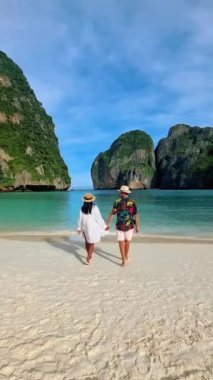 Maya Körfezi 'ndeki bir çift Koh Phi Phi Tayland, sahilde yürüyen kadın ve erkekler