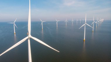 Hollanda 'da mavi gökyüzü yeşil enerji kavramına sahip elektrik üreten yel değirmeni türbinleri