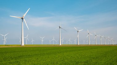 Windmill turbines generating electric with a blue sky green energy concept in the Netherlands clipart