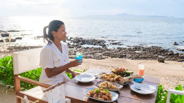 パタヤの海に面したレストランで昼食をとる女性パタヤの海に面したレストランで夕食をとる女性 — ストック写真