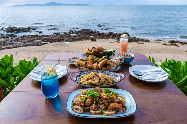 stock image Dinner table with Thai food and bbq fish on the beach of Pattaya Thailand during sunset