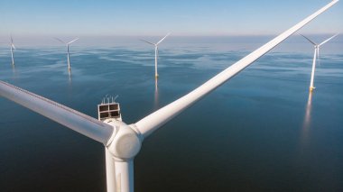 Mavi gökyüzü yeşil enerji kavramına sahip yel değirmeni türbinleri