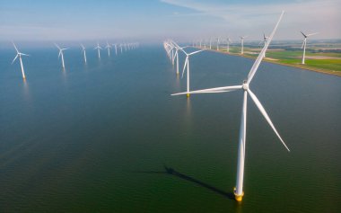 Mavi gökyüzü yeşil enerji kavramına sahip elektrik üreten rüzgar türbinleri, Hollanda 'daki yel değirmeni parkı