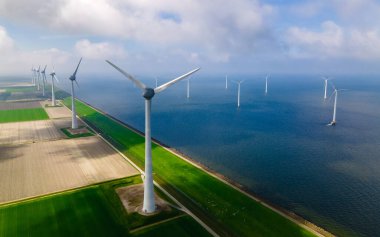 Rüzgâr değirmeni parkındaki hava manzarası kış boyunca türbinlerle mavi gökyüzü yeşil enerji kavramına sahip elektrik üretiyor.