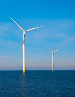 Rüzgâr değirmeni parkındaki hava manzarası kış boyunca türbinlerle mavi gökyüzü yeşil enerji kavramına sahip elektrik üretiyor.