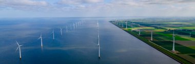 Hollanda 'daki Ijsselmeer Gölü' ndeki rüzgar türbinleriyle rüzgar değirmeni parkındaki hava manzarası.