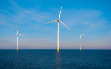 Rüzgâr değirmeni parkındaki hava manzarası kış boyunca türbinlerle mavi gökyüzü yeşil enerji kavramına sahip elektrik üretiyor.