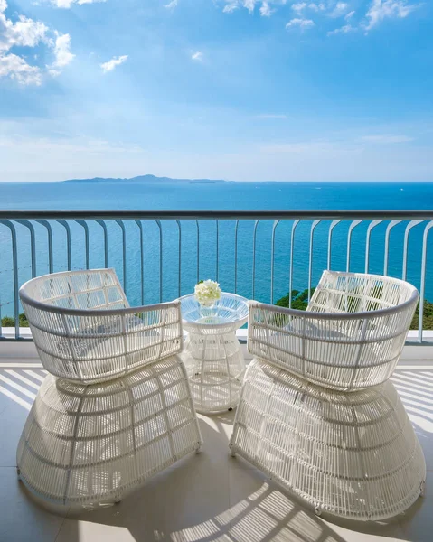 Chairs on the balcony with a view at the blue ocean on a balcony of a hotel