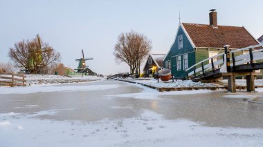 Kış boyunca Zaanse Schans yel değirmeni köyü kışın gün doğumunda Hollanda 'nın Hollanda köyünde kar manzarası ile