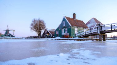 Kış boyunca Zaanse Schans yel değirmeni köyünde kışın Hollanda 'nın Hollanda köyünde kar manzarası vardı.
