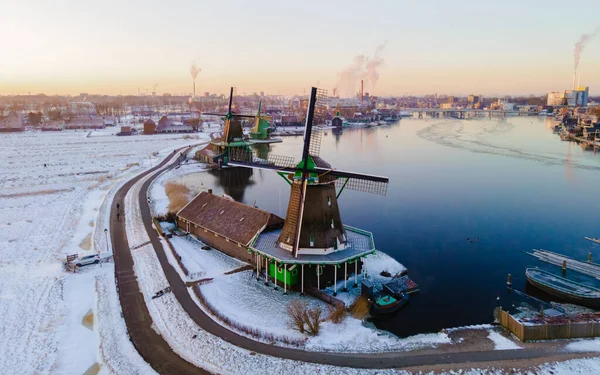 Zaanse Schans windmill village during winter with snow landscape in the Netherlands Holland village in winter. Drone aerial view in the morning at the windmill village